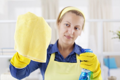Cleaner wearing protective gloves and assessing workplace safety procedures